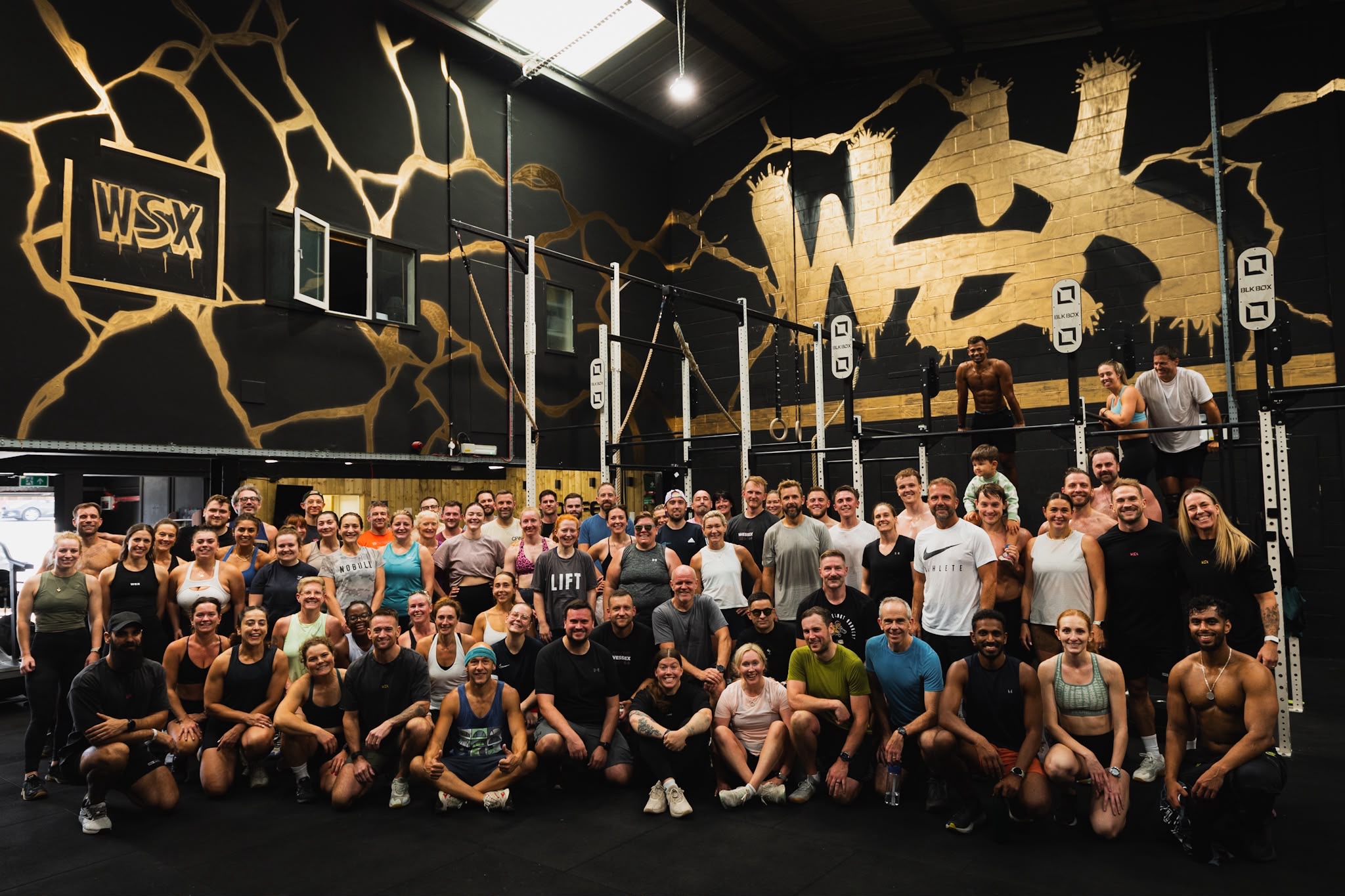 The WSX community: around seventy members of all ages gathered on the gym floor under the gold WSX wall